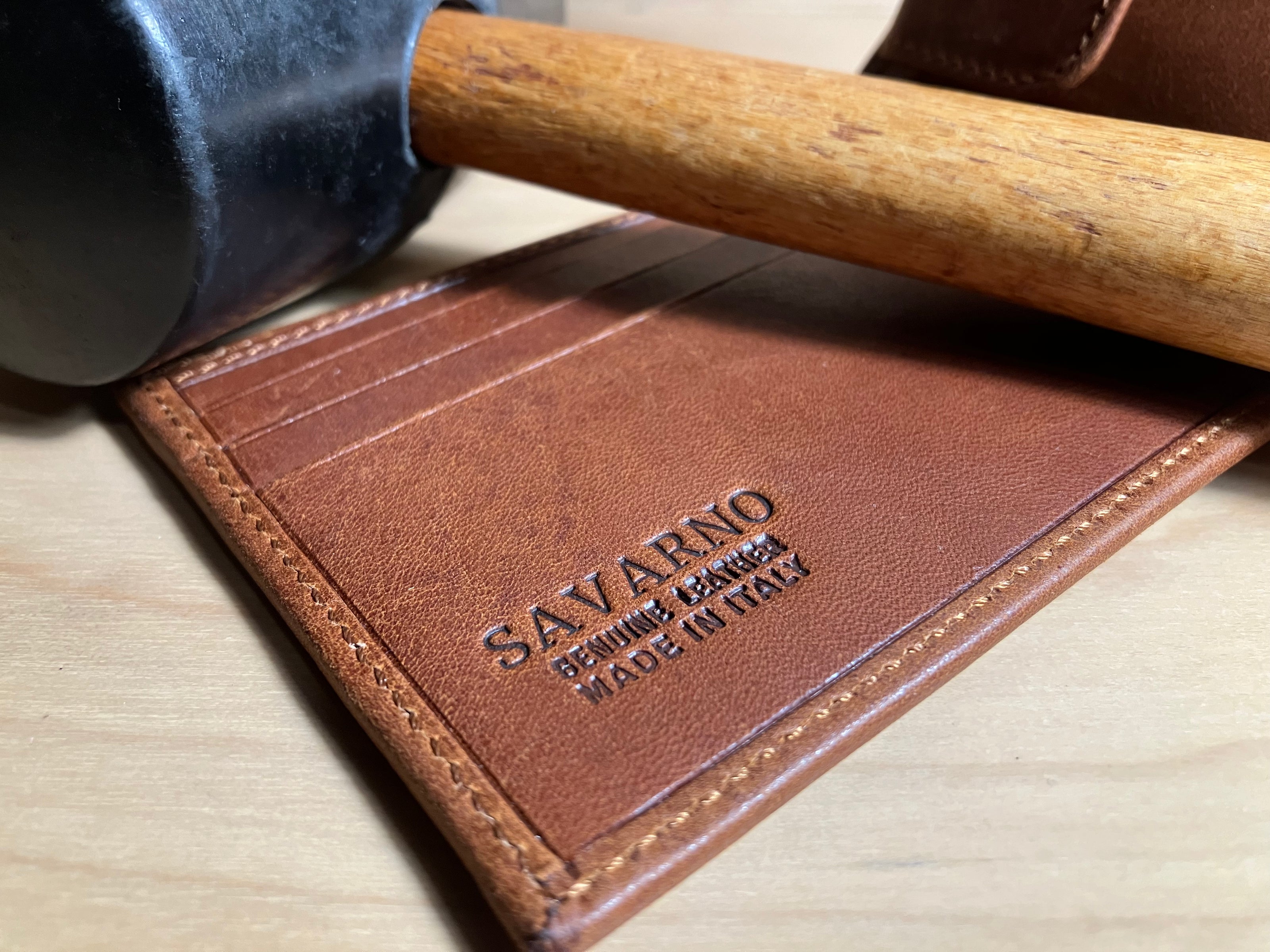 Savarno classic brown bi-fold wallet with a mallet used for leather work